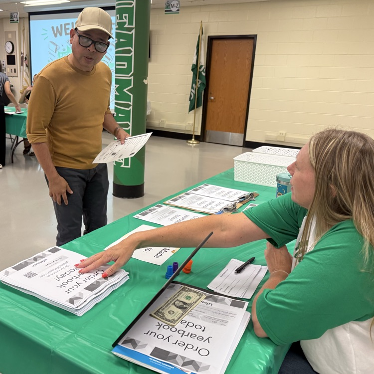 Ms. Morrison helping a parent sign up for Yearbooks.