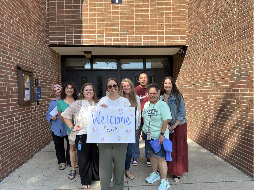 Group of teachers with Welcome Back sign. 