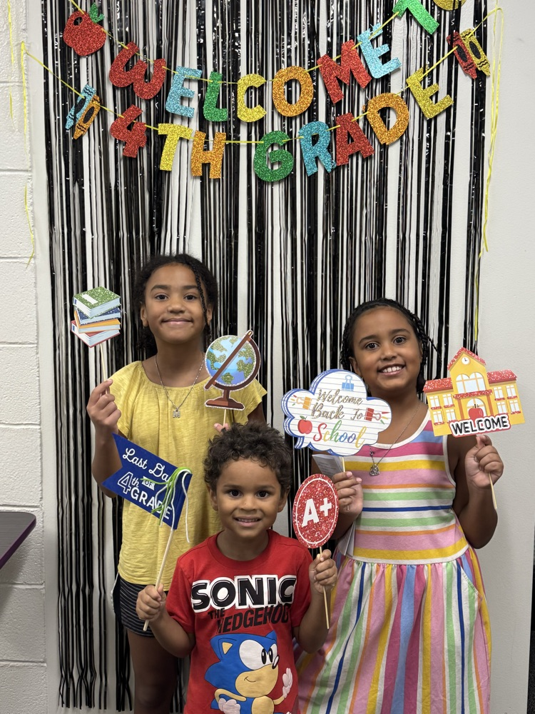 three children holding back to school signs