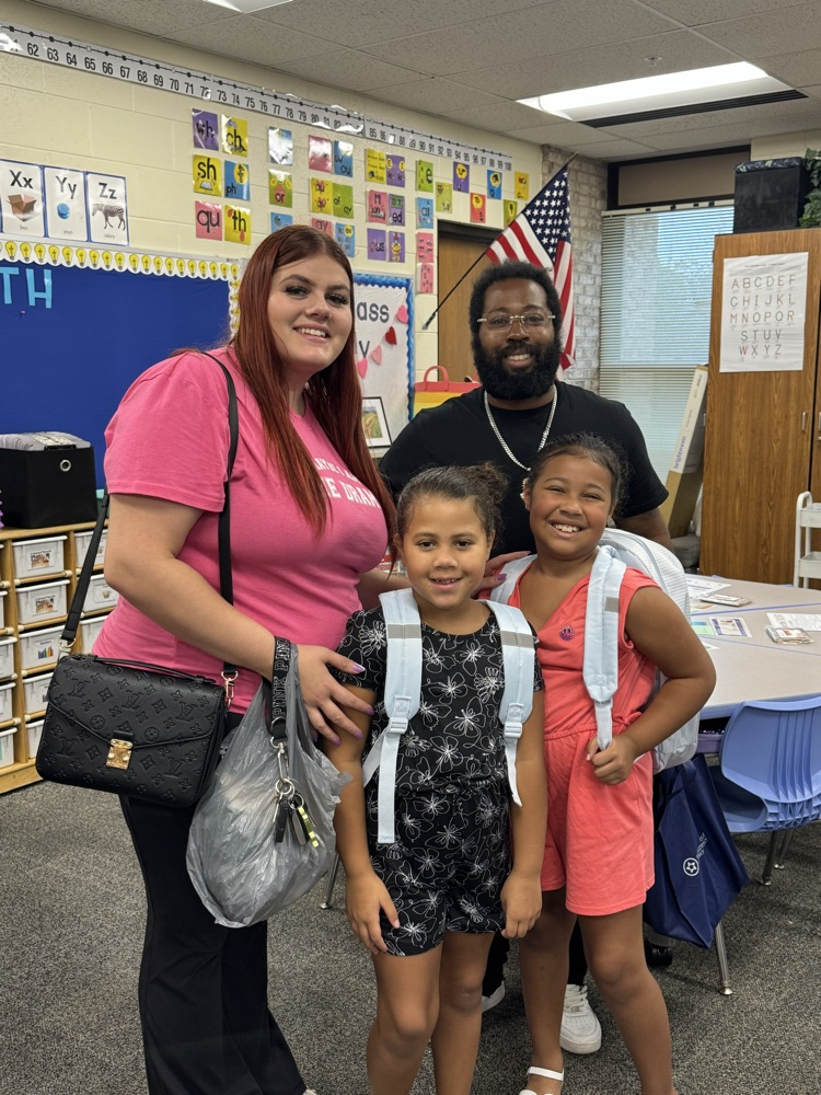 family smiling in a classroom