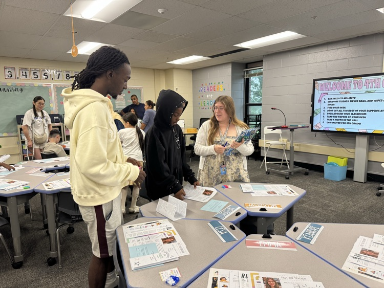 family talking to a teacher in a classroom