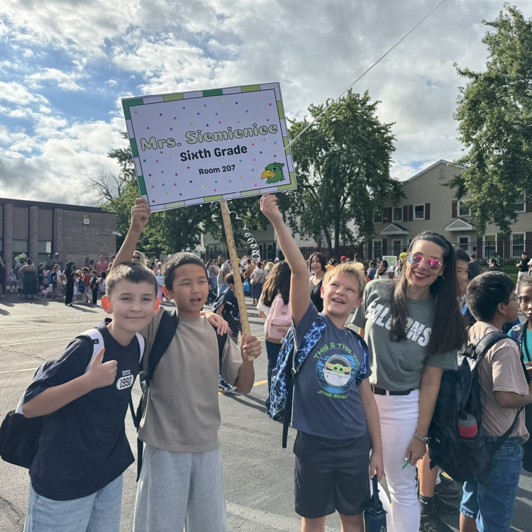 teacher and students smiling in parking lot