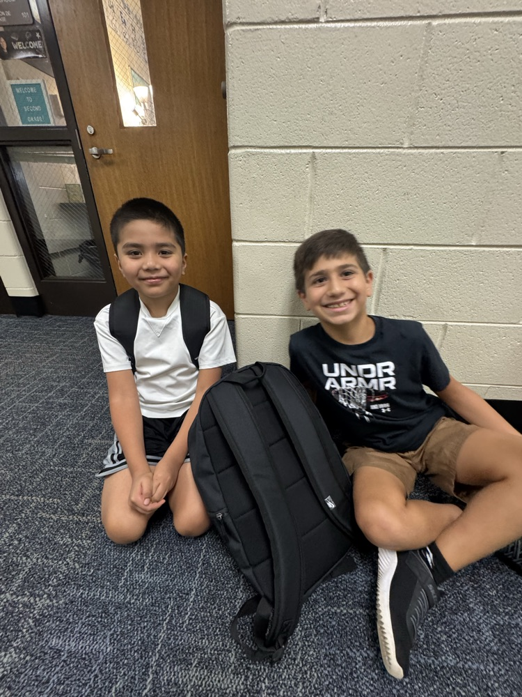 Two friends sitting next to each other in the hall.