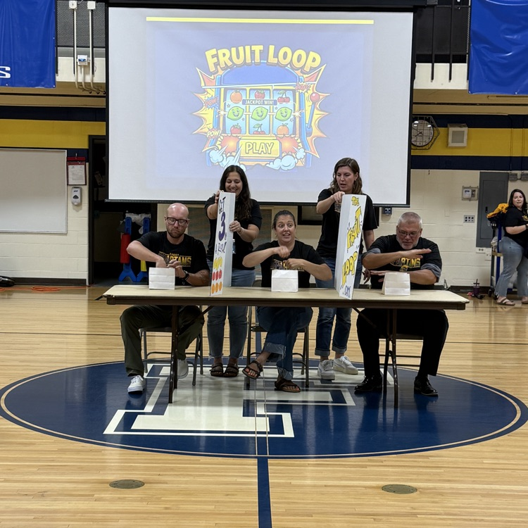 gymnasium with three adults sitting at a table
