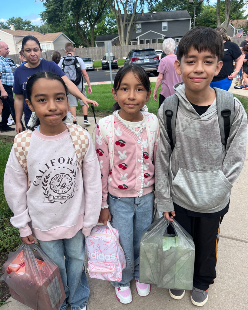 3 soblings smiling together outside with backpacks on before their first day