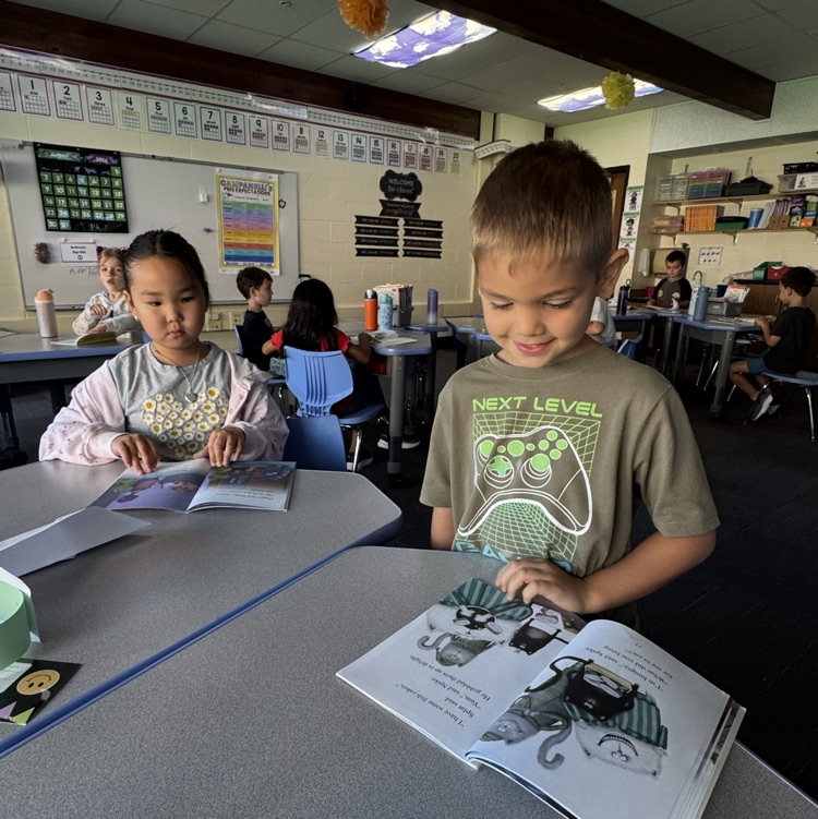 a girl and a boy reading a book