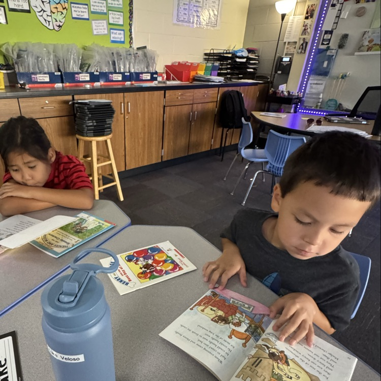 a boy and girl reading a book 