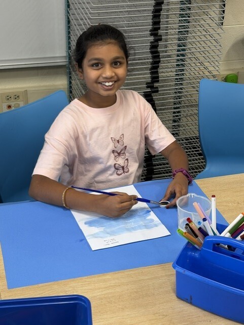 Student revealing a secrect message with water color paints
