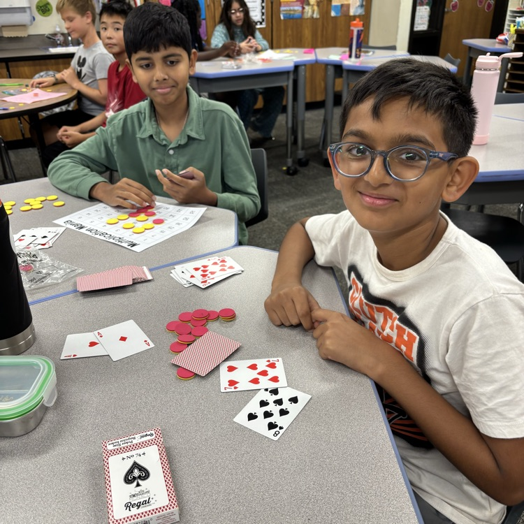 Two students playing a game with cards