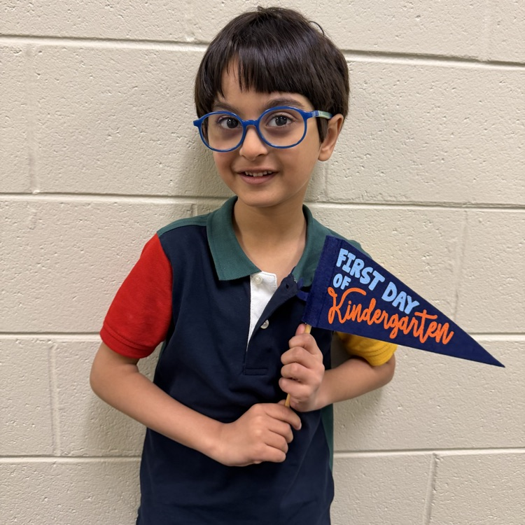 Kinder with a first day of school flag.