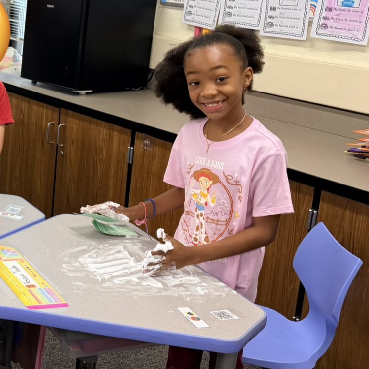 Girl writing numbers in shaving cream