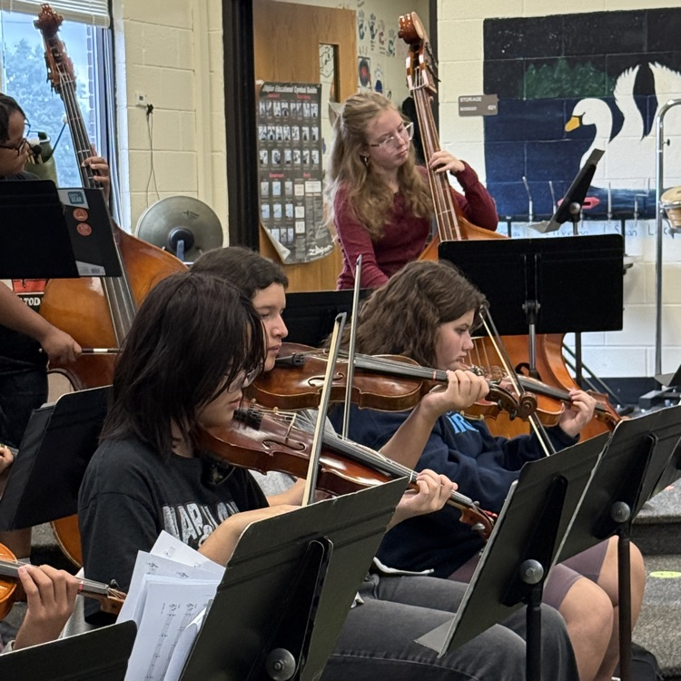 Junior high students playing violins