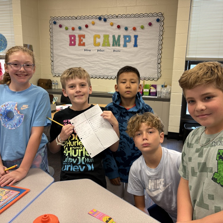 Five students showing their writing