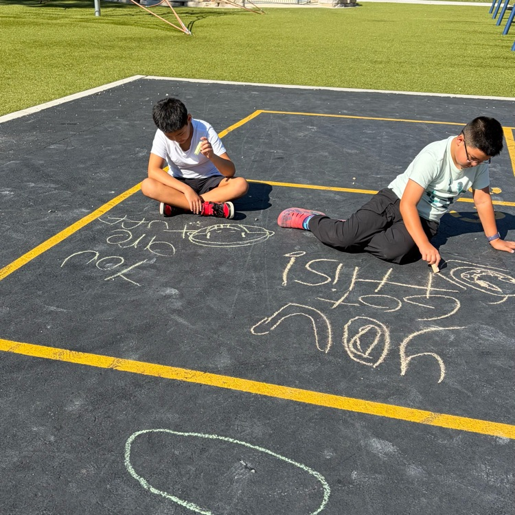 students writing positive messages in chalk