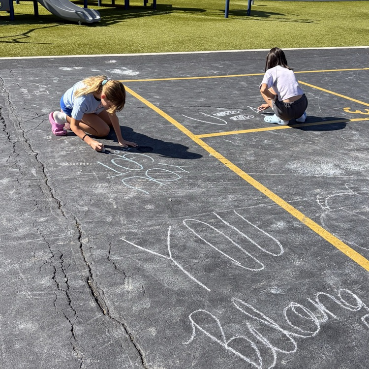 students writing positive messages in chalk