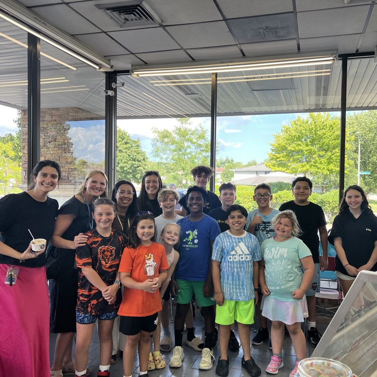 Ms.Moradi holding ice cream and standing with students