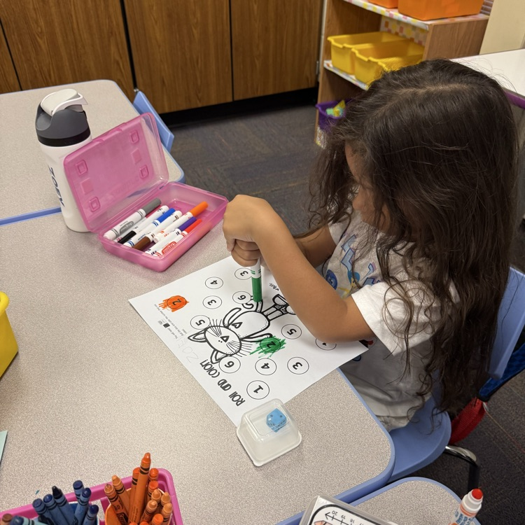 a student coloring a number on a paper