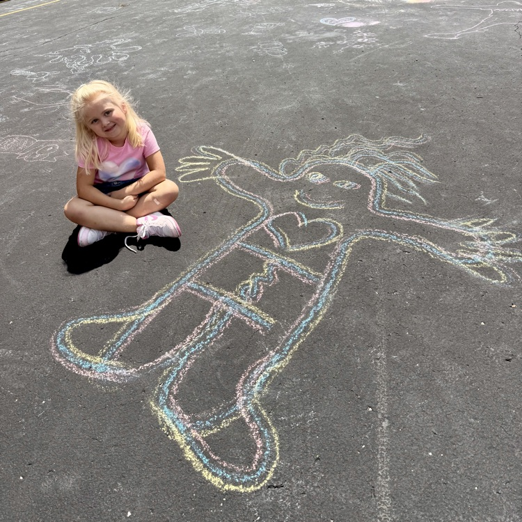 Student next to chalk person drawn on blacktop