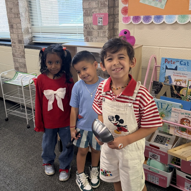 three students standing and smiling