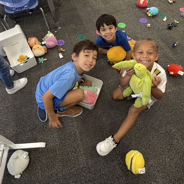 three students playing on the floor