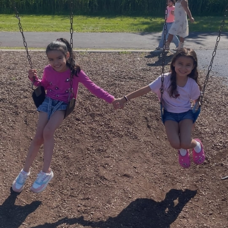 kids on swings holding hands