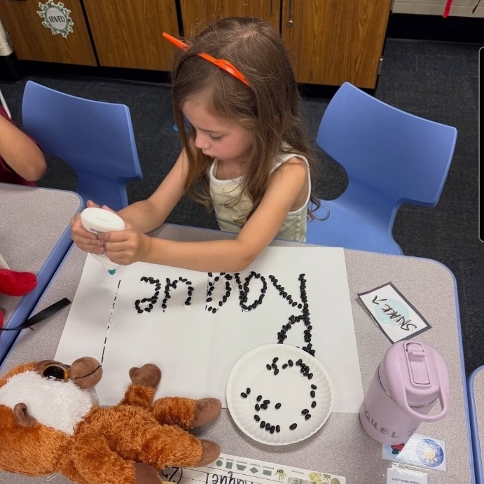 kindergarten making the letters in their name with beans and glue