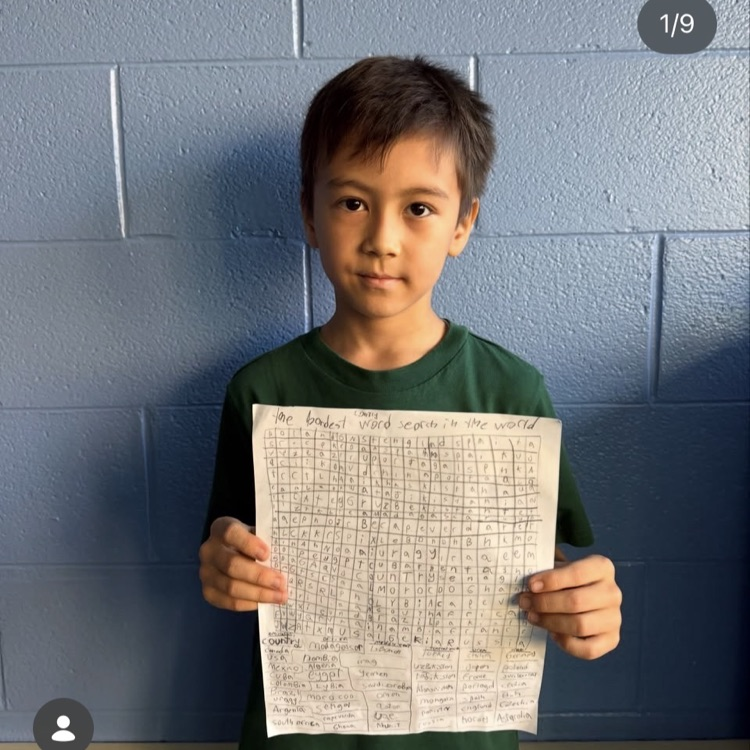 student holding word search he created