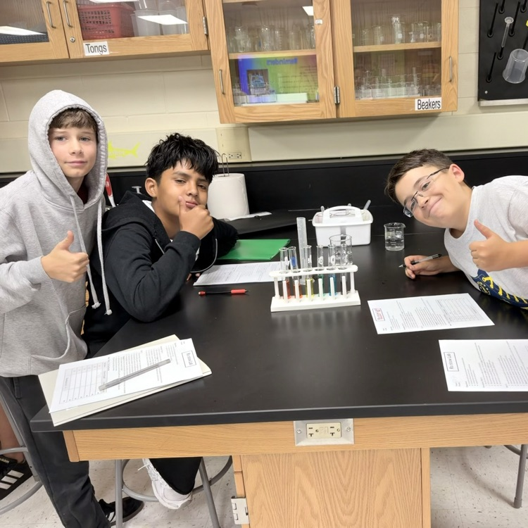 four boys standing in a science lab