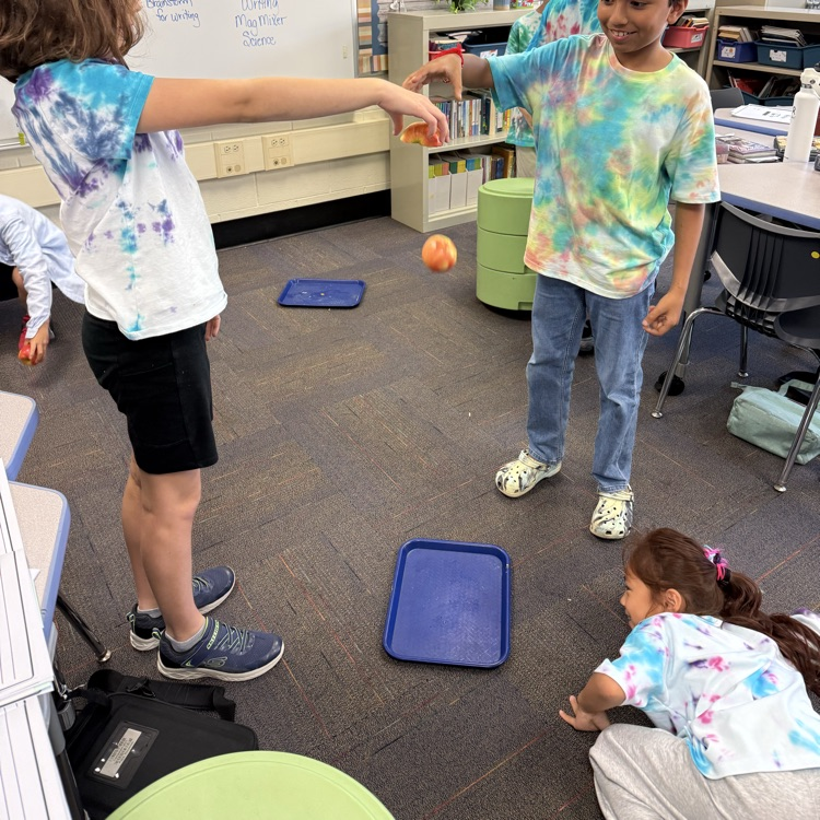 two students  getting ready to drop apples