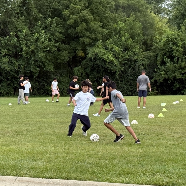 teens playing soccer on grass