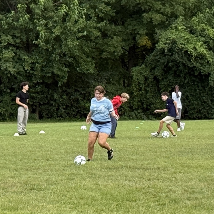 teens playing soccer in a field