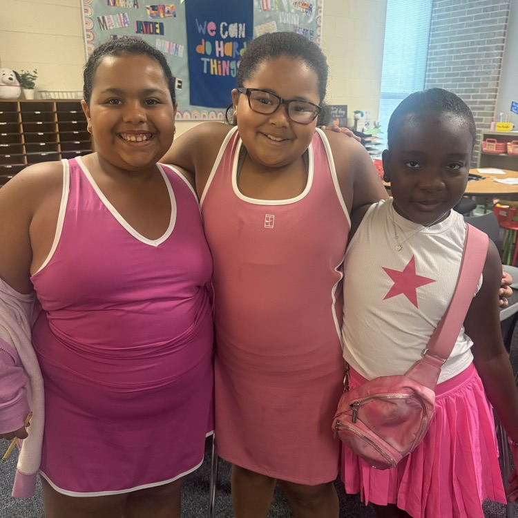 Three girls wearing similar pink dresses.