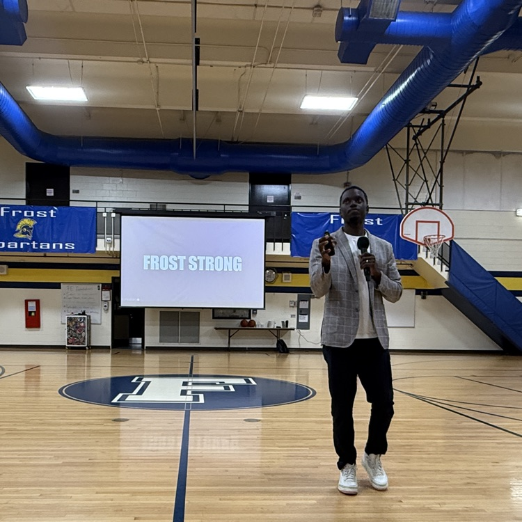 man holding microphone speaking in gym