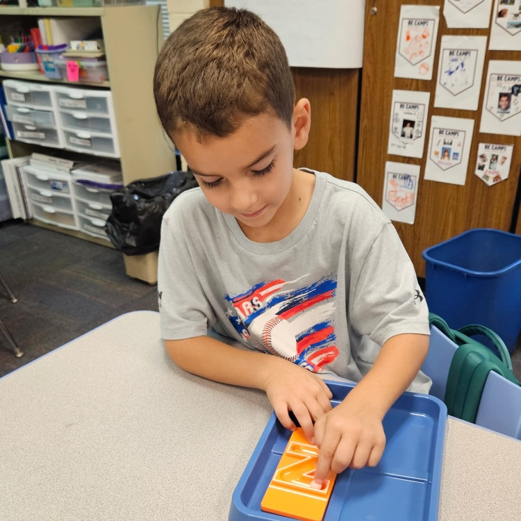  student creating the letter z with marbles 