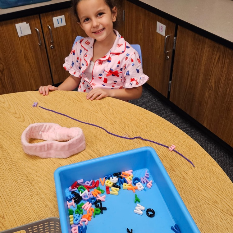 student stringing letter beads