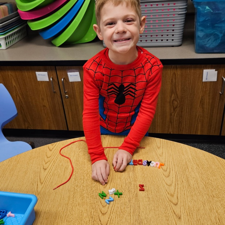student stringing letter beads