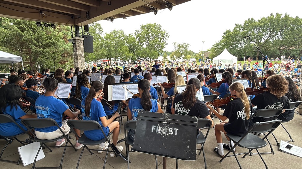 Band and Orchestra students playing their instruments at a festival