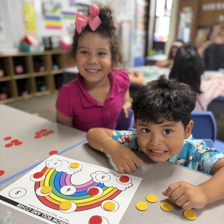 Kindergarten mathematicians posing with their game board