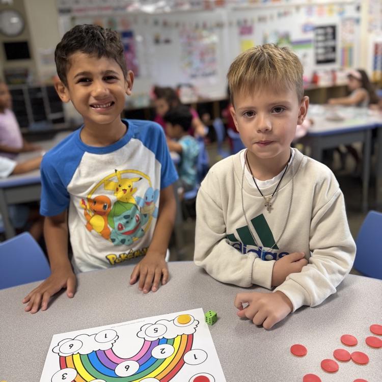 Kindergarten mathematicians posing with their game board
