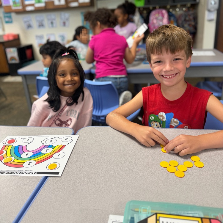 Kindergarten mathematicians posing with their game board