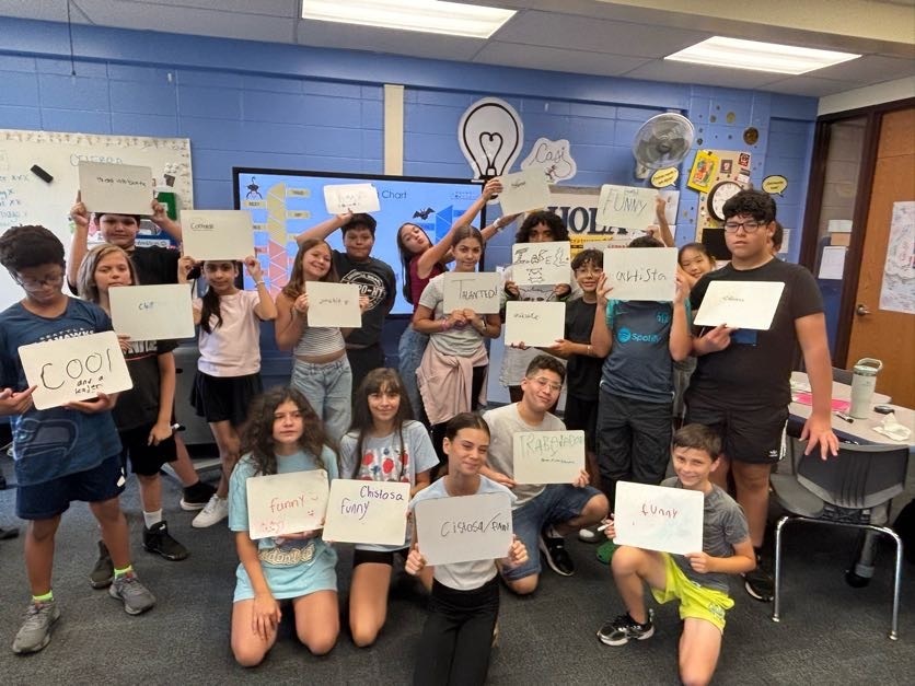 Student hold up positive messages for student of the week