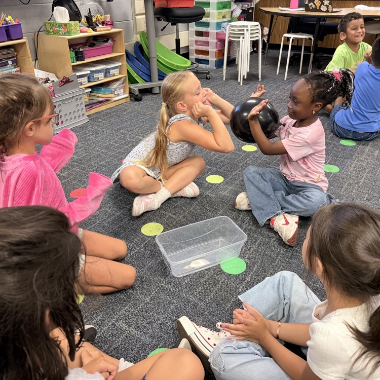 2nd Graders passing a balloon in groups.