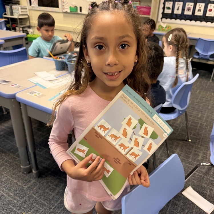Kindergartener with her math page.