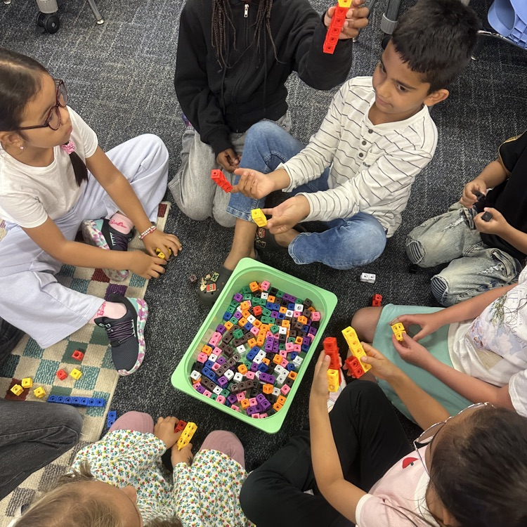 Students using cubes in small group.