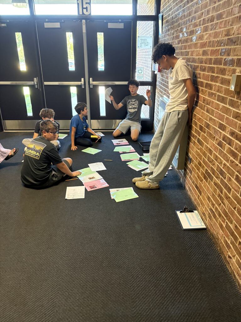 Students in a hallway collaborating on an assignment