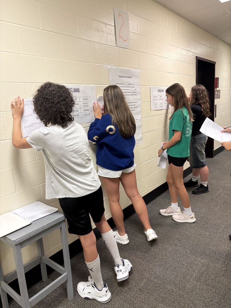 Students in a hallway collaborating on an assignment