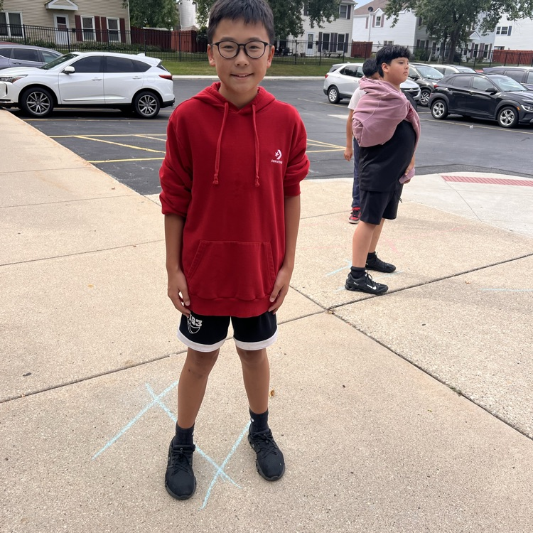 student standing on chalk lines on sidewalk