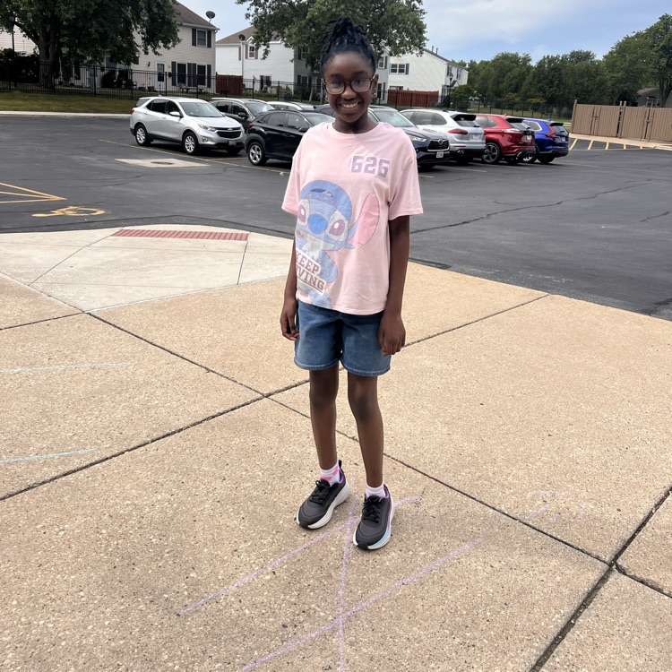 student standing on chalk lines on sidewalk