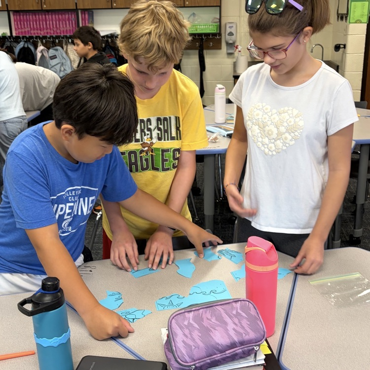 6th graders putting a puzzle together.
