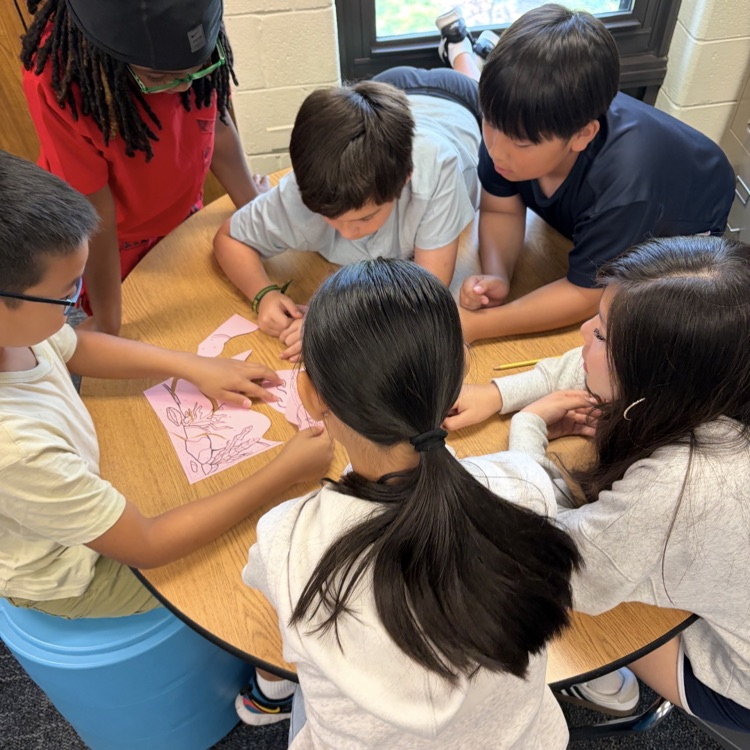 6th graders working together to complete a puzzle.